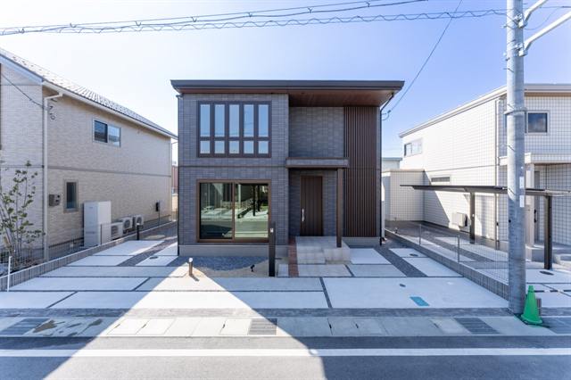 街並みに溶け込む落ち着いた色合いの外壁色、上下大きさを揃えた大開口が魅力的な外観。